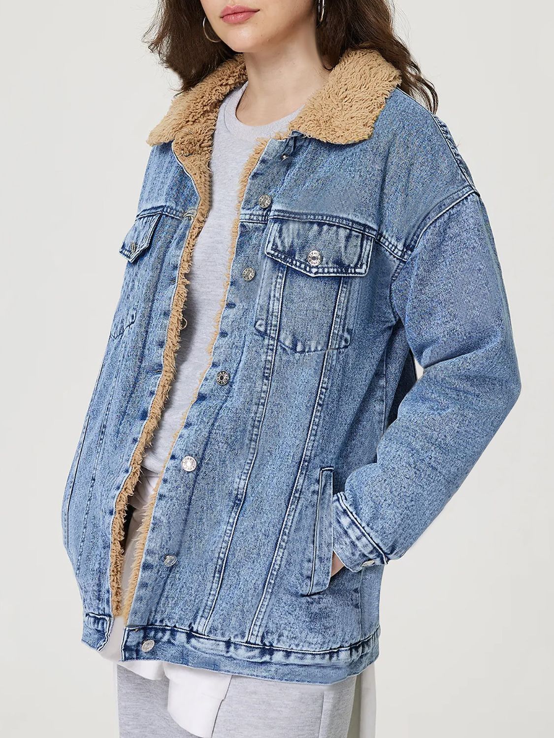 Sherpa-lined oversized acid wash denim trucker jacket with collar and button details.