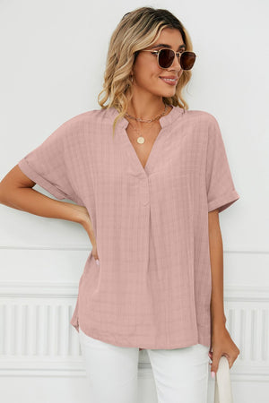 Dusty pink linen blouse with V-neck and short sleeves, featuring a subtle textured pattern.