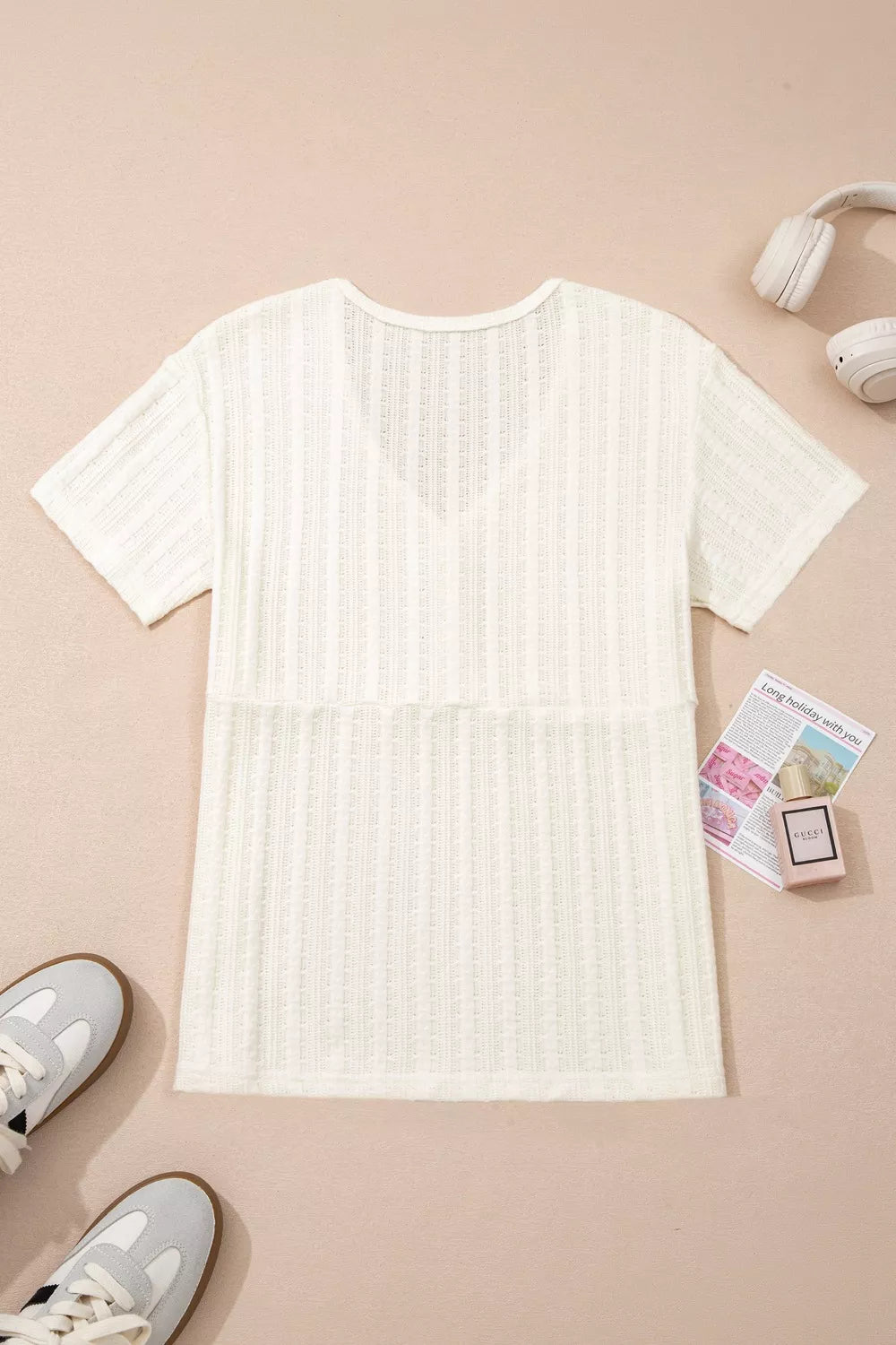 Textured white maternity t-shirt with V-neck and short sleeves, featuring button details.