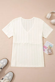 Textured white maternity t-shirt with V-neck and short sleeves, featuring button details.