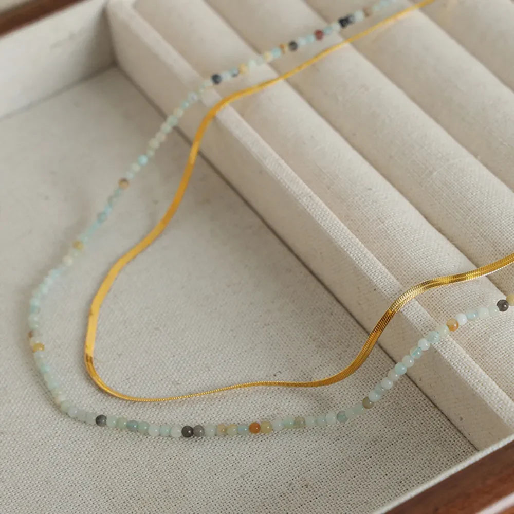 Gold serpentine chain and beaded layered necklace set with subtle crystal accents.