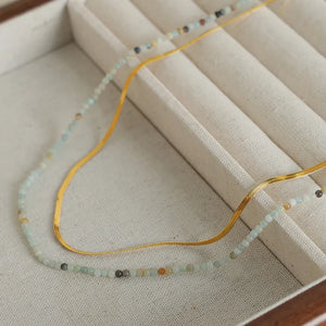 Gold serpentine chain and beaded layered necklace set with subtle crystal accents.