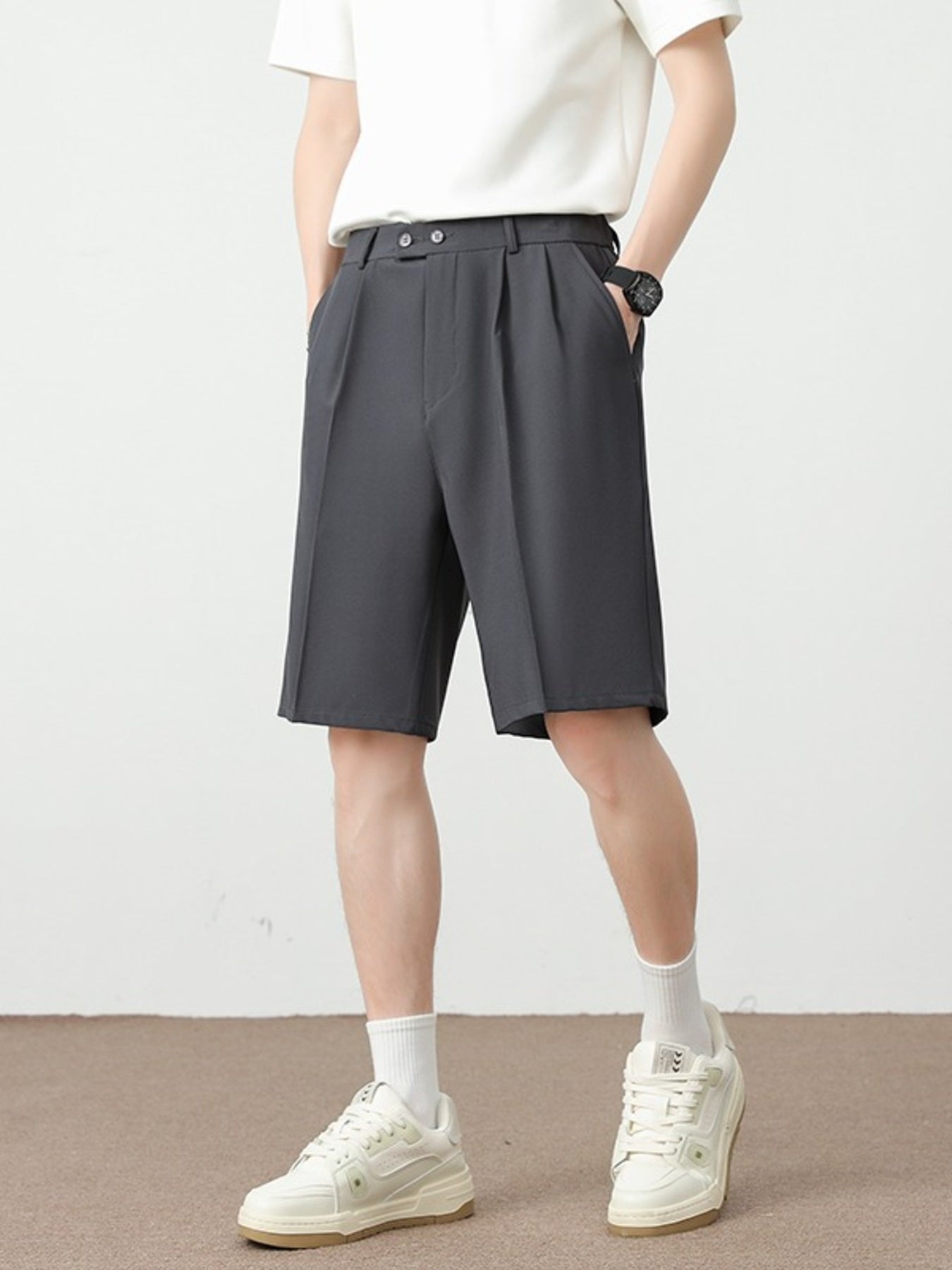 Men's dark gray chino shorts with pleats and a loose fit.