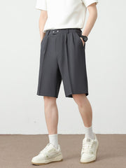 Men's dark gray chino shorts with pleats and a loose fit.