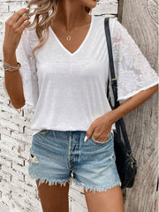 White V-neck tee with lace inset flared sleeves and raw hem denim shorts.