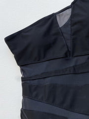 Black asymmetrical one-piece swimsuit with mesh panels and strap details.