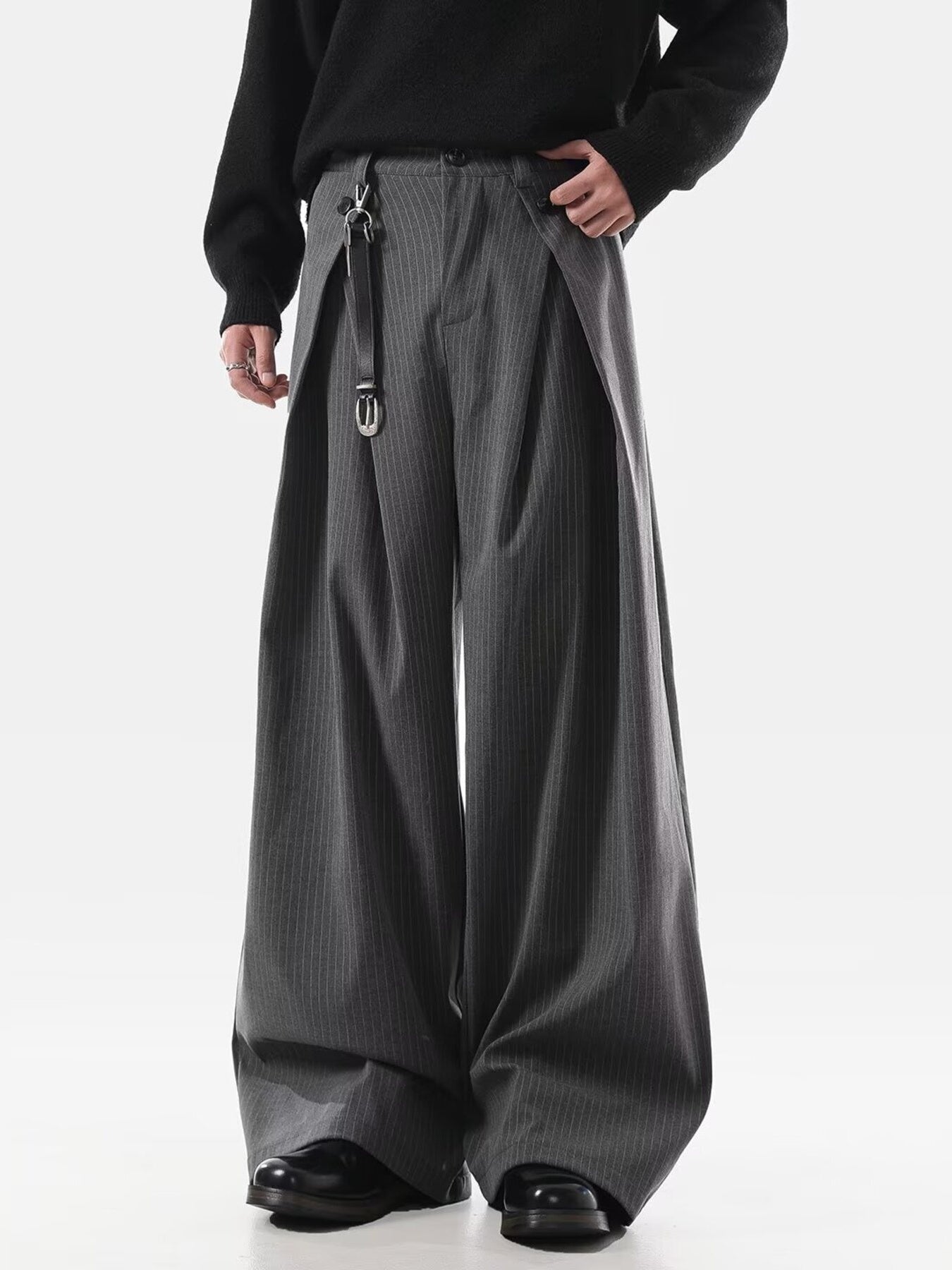 Men's grey pinstripe wide leg sweatpants with pleats and a belt detail.