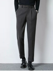 Men's dark gray tailored pleated dress pants with cuffed hems.