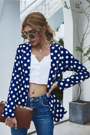 Dark blue polka dot open-front blazer with long sleeves, styled with a white crop top and jeans.