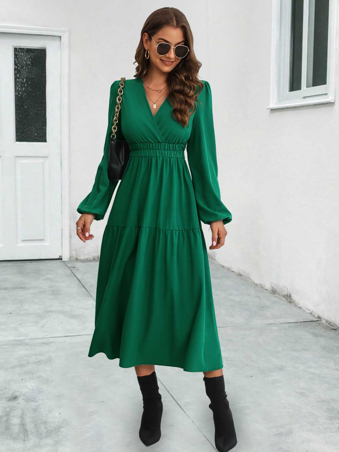 Dark green tiered midi dress with V-neck, long sleeves, and gathered waistline.