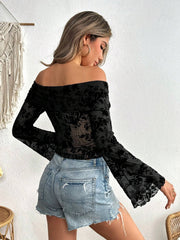 Black velvet floral off-shoulder blouse with bell sleeves and sheer fabric.