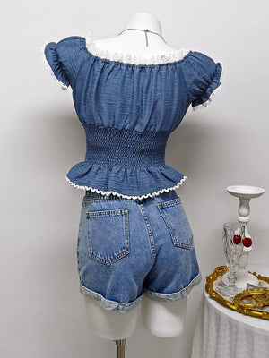 Blue ruffled smocked maternity blouse with puff sleeves and white lace trim.