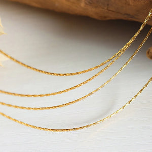 Delicate multi-strand gold-plated collar necklace with textured chains.