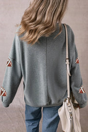 Dark gray sweatshirt with football sequin embellishments on sleeves.