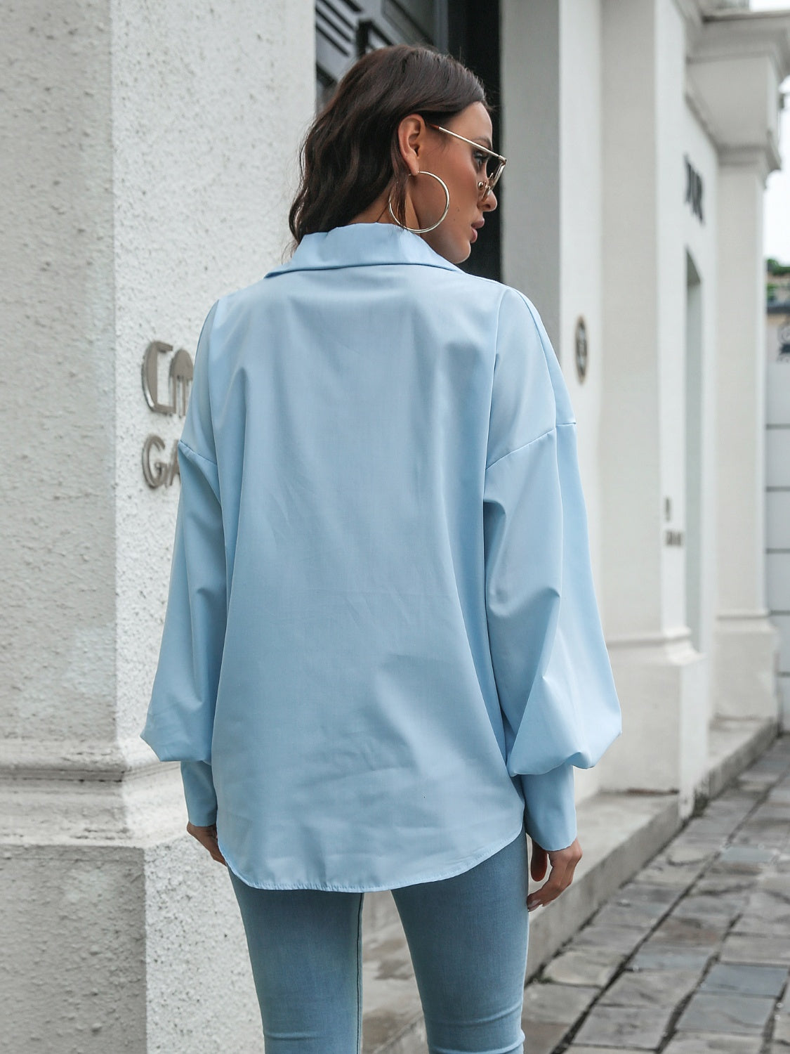 Light blue poplin button-down blouse with balloon sleeves and a relaxed fit.