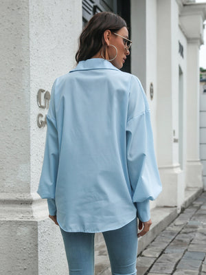 Light blue poplin button-down blouse with balloon sleeves and a relaxed fit.
