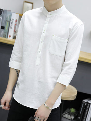 White cotton shirt with button detail, mandarin collar, chest pocket, and 3/4 sleeves.