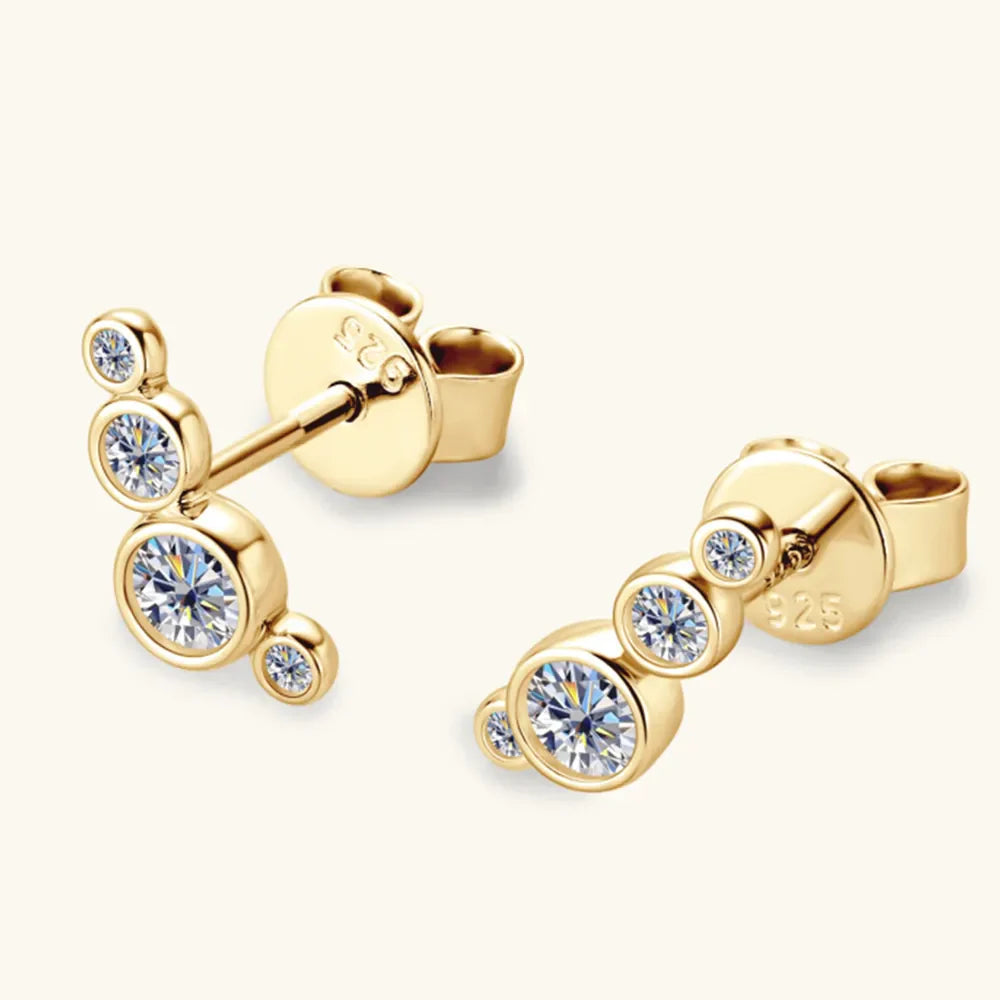 Gold ear climbers with bezel-set cubic zirconia stones in a cluster design.
