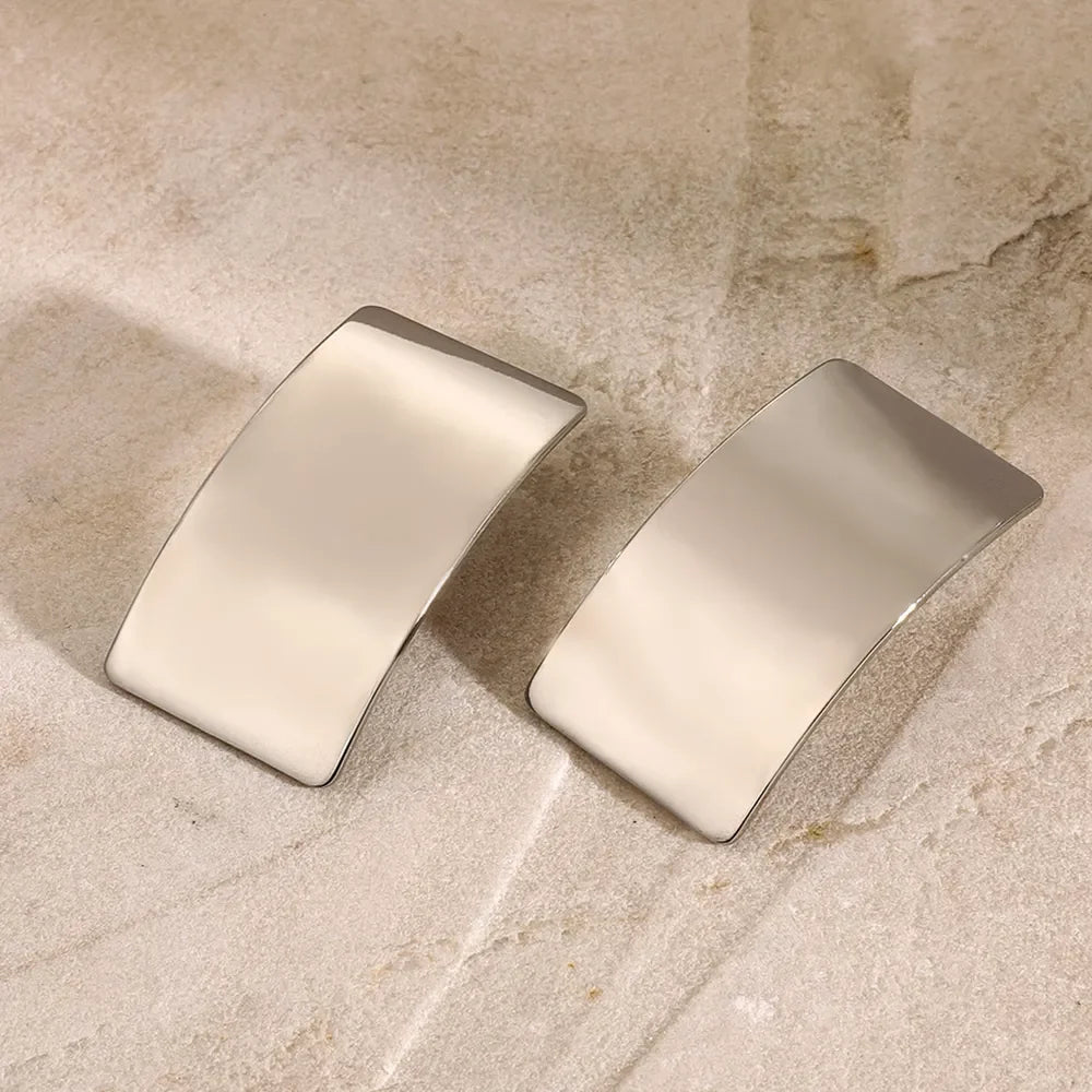 Sculpted silver-tone statement earrings with a bold, casual style.