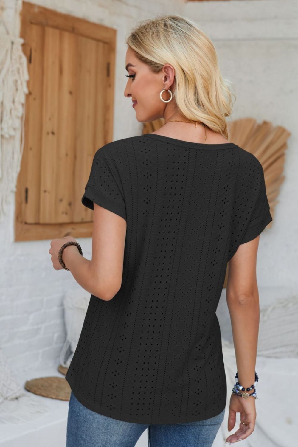 Black perforated eyelet cuffed tee with short sleeves and a v-neck.
