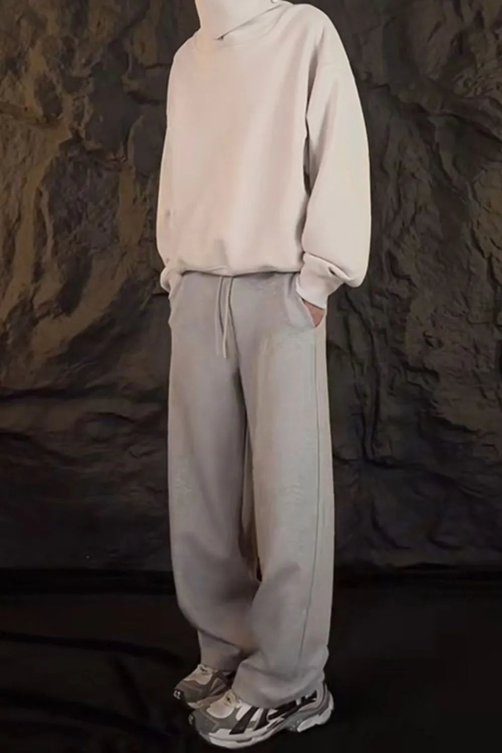 Relaxed-fit lounge trousers in dark gray with a drawstring waist and side pockets.