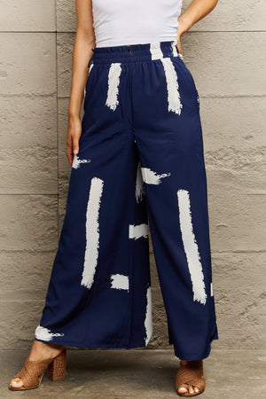 Navy palazzo trousers with a white brushstroke pattern and elastic waist.