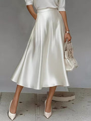 White satin A-line midi skirt with pockets, flowing silhouette