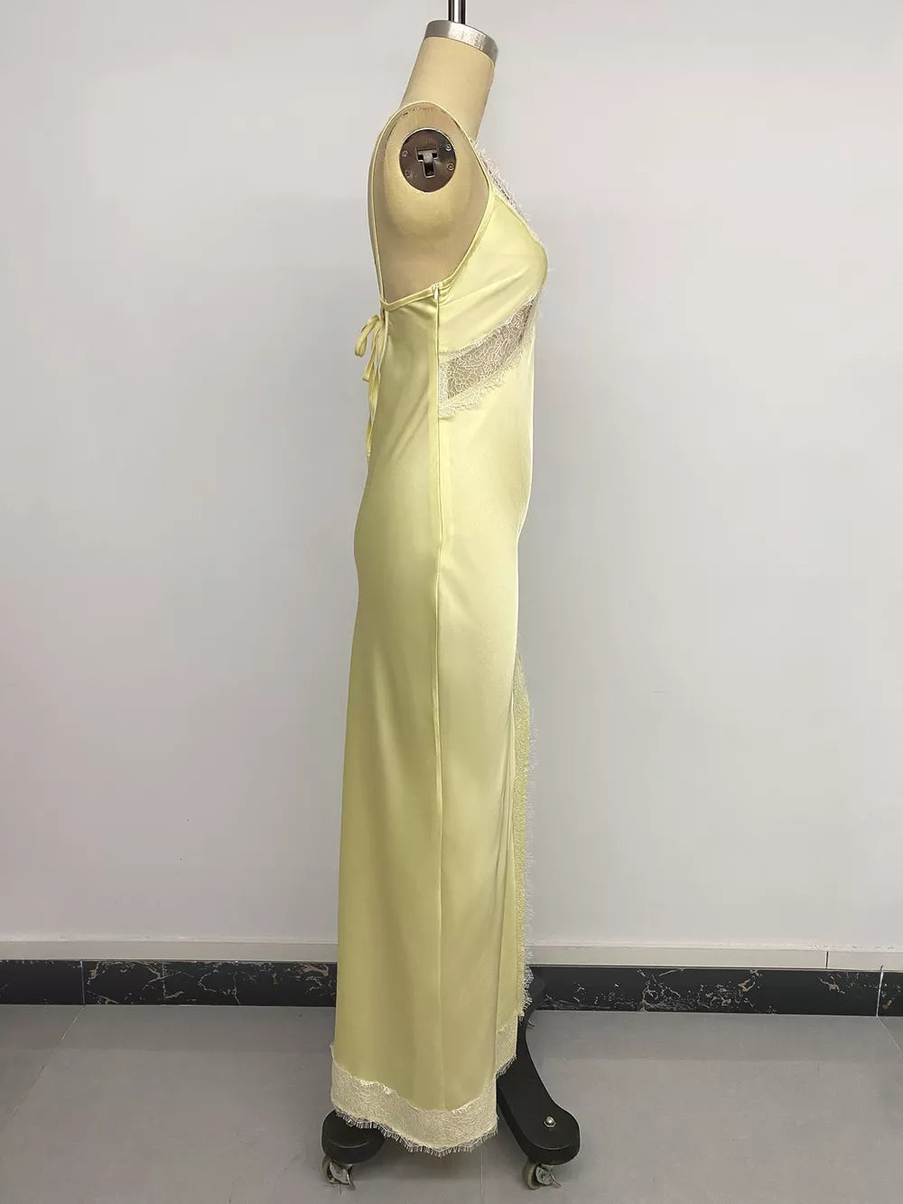 Yellow satin midi slip dress with lace trim and side slit detail.
