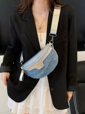 Crescent mini denim crossbody bag with silver accents and chain detail.