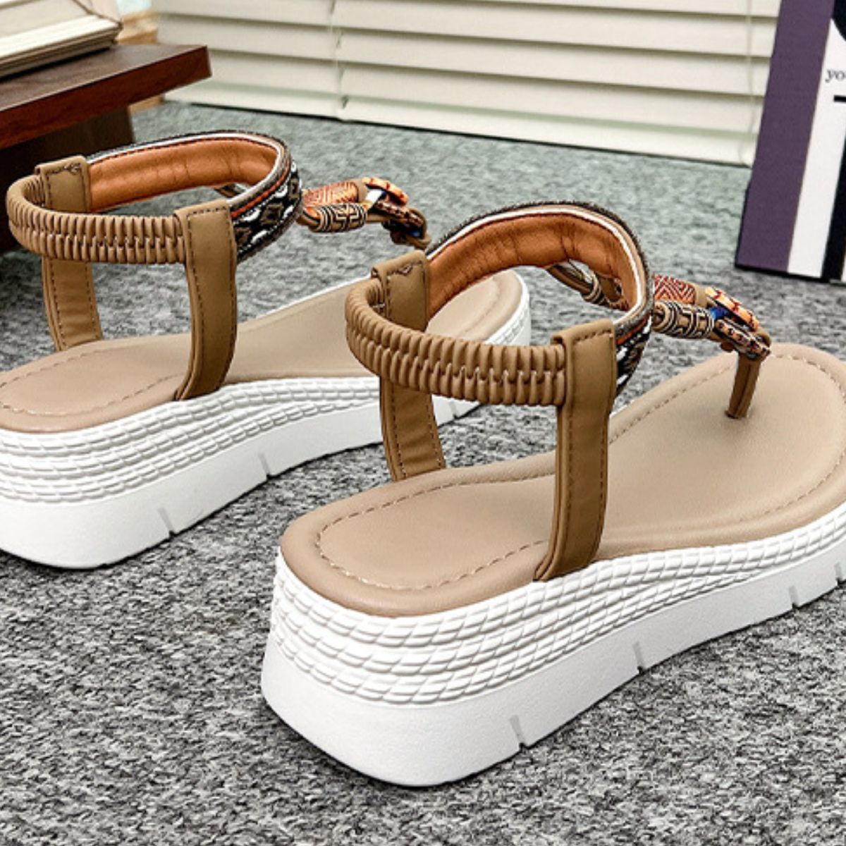 Khaki ethnic-patterned wedge sandals with floral accents and ankle straps.