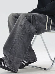 Oversized dark gray denim cargo jeans with drawstring waist and flap pockets.