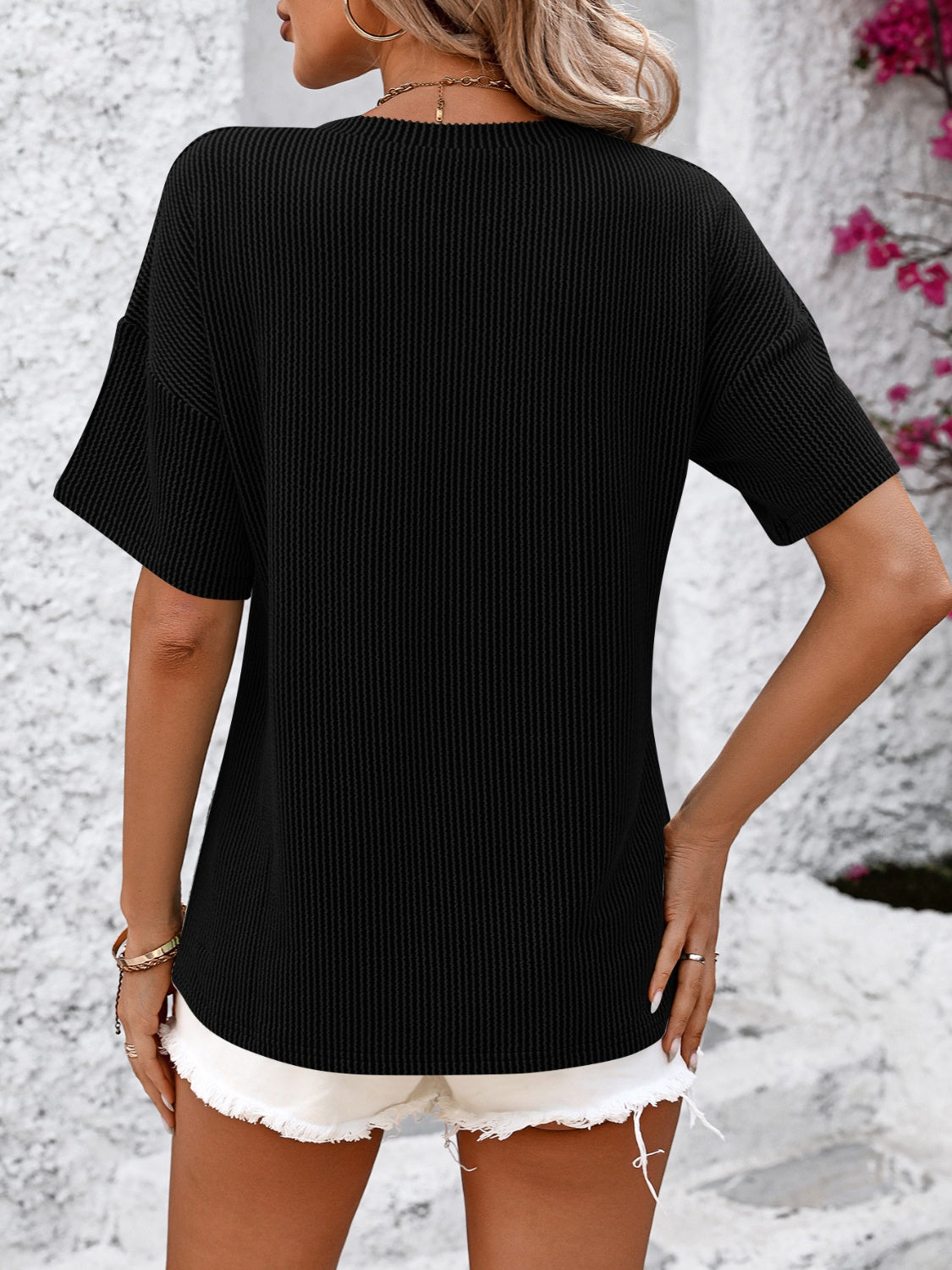 Black textured ribbed V-neck pocket tee with short sleeves.