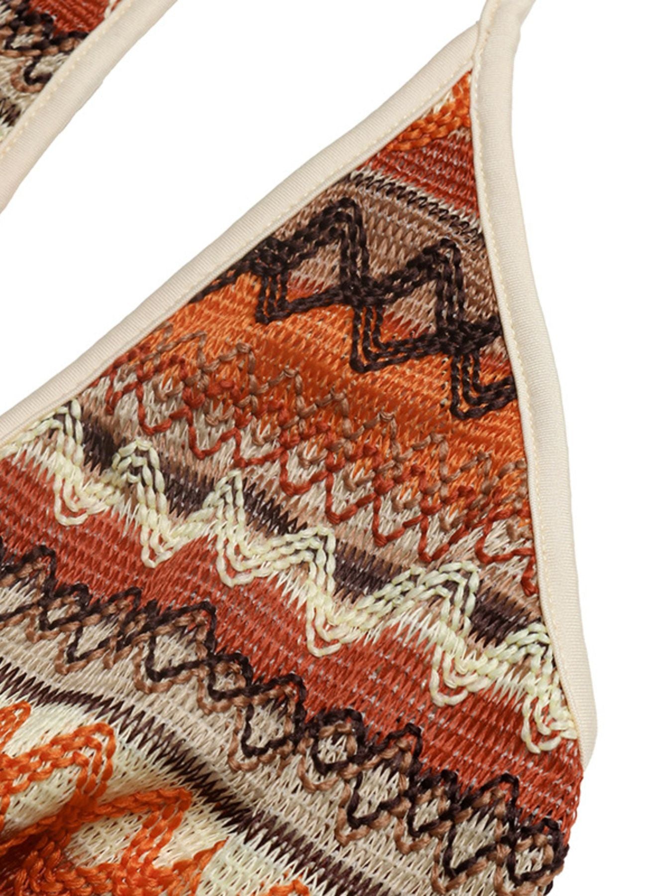 Geometric pattern halter jumpsuit in beige, orange, and brown knit fabric with a zigzag design.