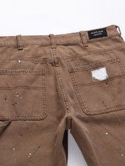 Taupe carpenter trousers with artisan paint splatters and distressed details.