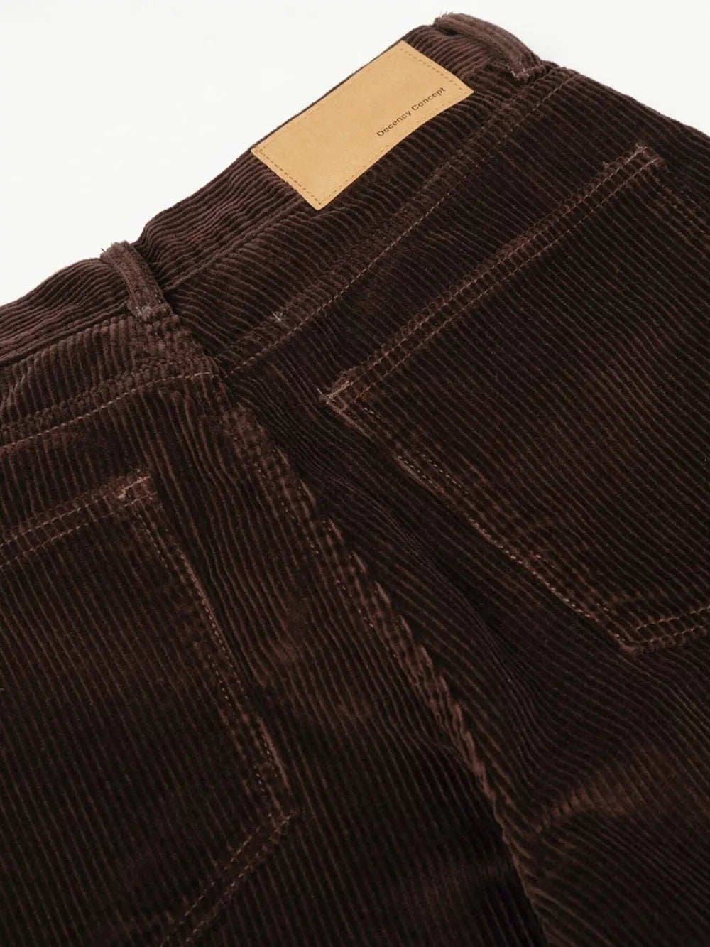 Brown corduroy wide-leg joggers with button fly and leather patch detail.