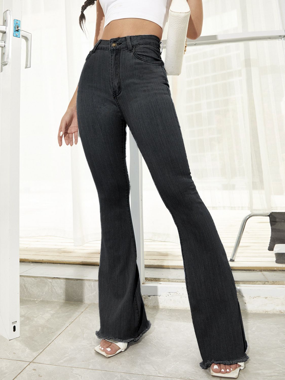 Black bootcut denim trousers with raw hem detail