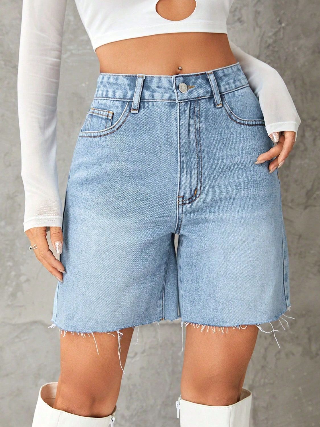 Light blue denim high-waisted bermuda shorts with frayed hem and button closure.