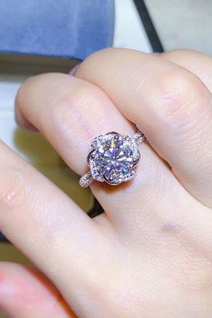 Silver floral halo moissanite engagement ring with a bright center stone.