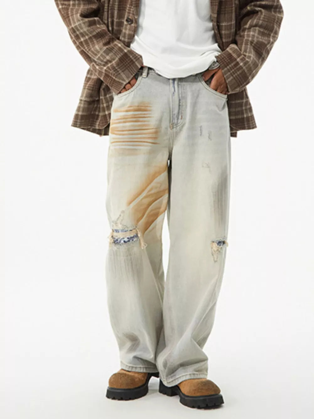 Distressed light wash wide-leg jeans with unique tan paint splatters and ripped knee details.