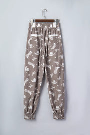 Vintage western print drawstring joggers in taupe cotton with cowboy boots and cactus pattern.