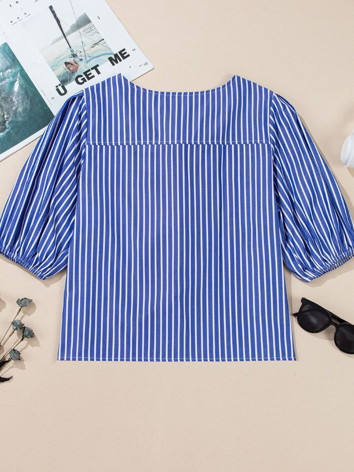 Blue striped blouse with puff sleeves and a tie-front detail.