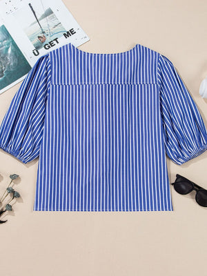 Blue striped blouse with puff sleeves and a tie-front detail.