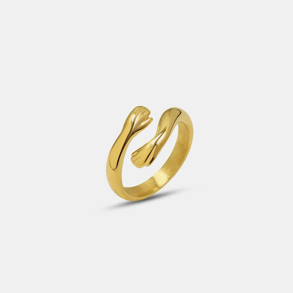Gold embracing hands open ring with a chic, casual design.