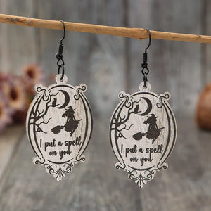 Black wood drop earrings with witch, cat, moon, and spell text.