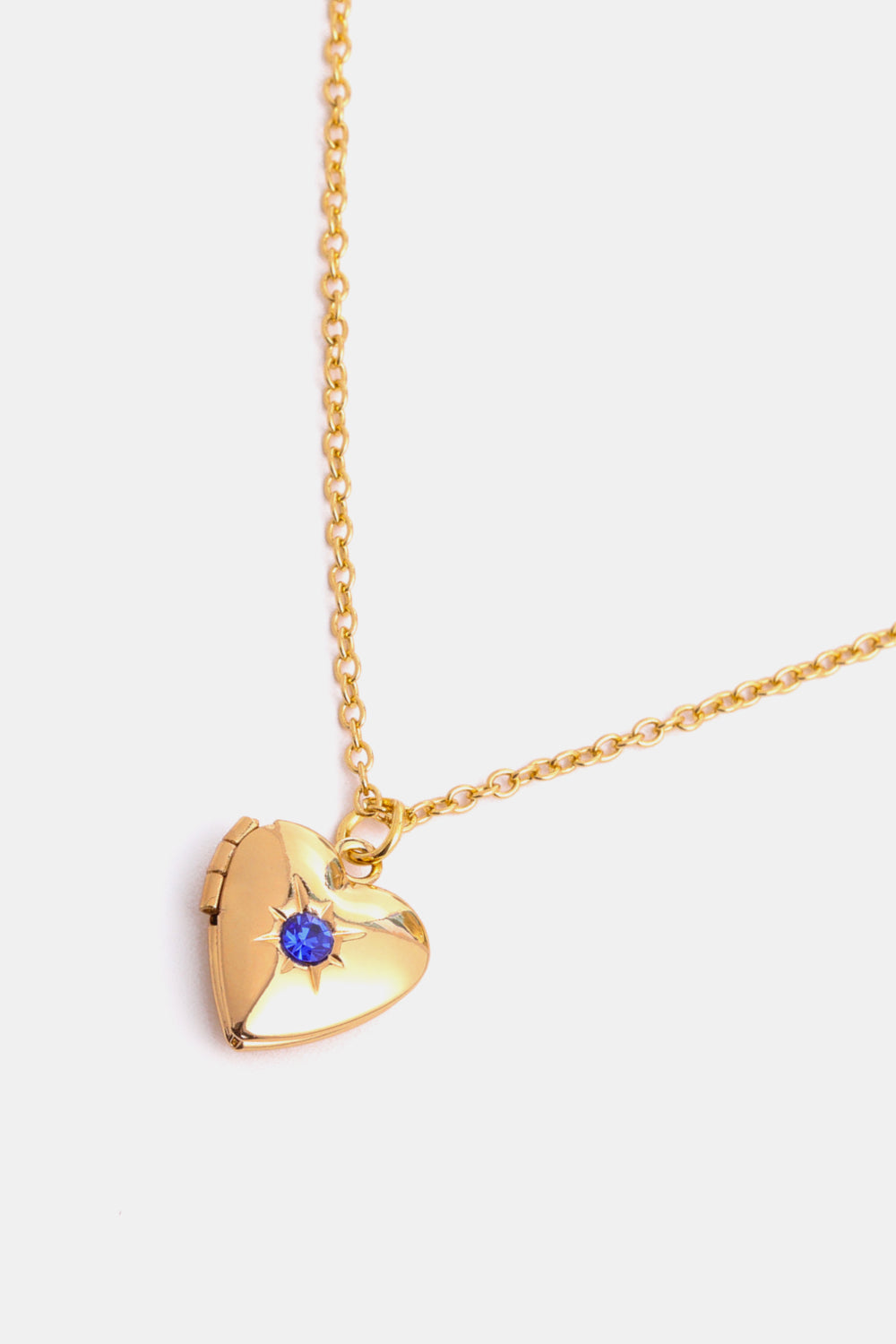 Gold heart locket necklace with blue gemstone and starburst detail, 14k gold chain