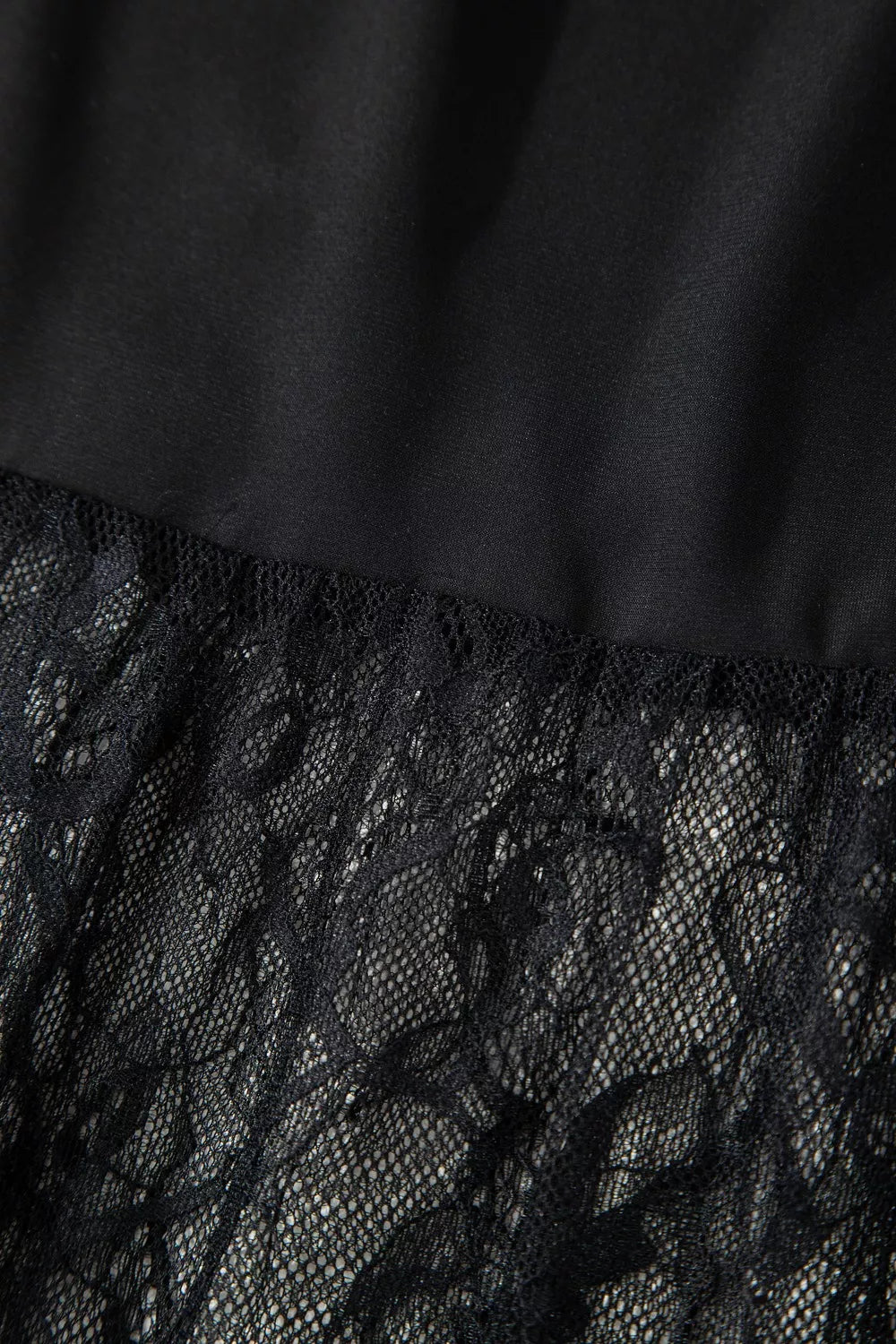 Black lace maxi dress detail with sheer lace overlay and smooth fabric.