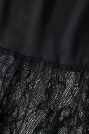 Black lace maxi dress detail with sheer lace overlay and smooth fabric.