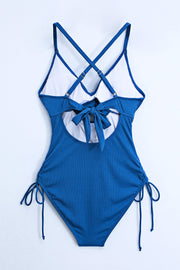 Ribbed one-piece swimsuit in Peacock Blue with crisscross straps, back tie, and side tie details.