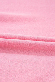 Pink knit blouse with textured fabric and a folded detail.