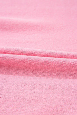 Pink knit blouse with textured fabric and a folded detail.